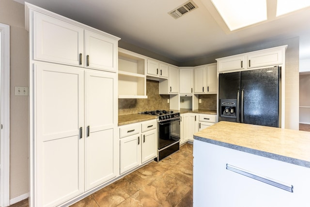 kitchen with black appliances, tasteful backsplash, and white cabinetry