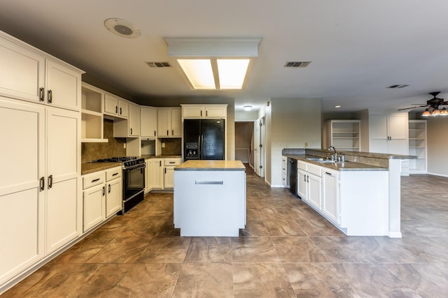 kitchen featuring a center island, black appliances, white cabinets, ceiling fan, and sink