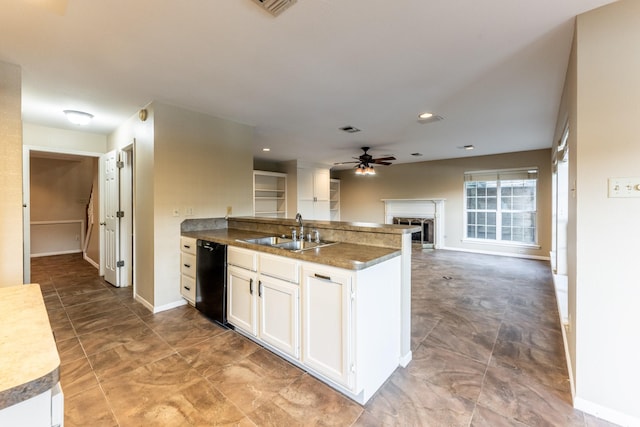 kitchen with kitchen peninsula, white cabinets, ceiling fan, black dishwasher, and sink