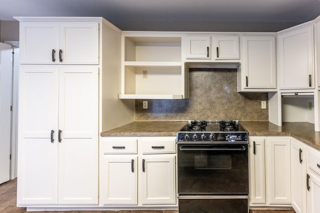 kitchen featuring black range with electric cooktop, white cabinetry, and decorative backsplash