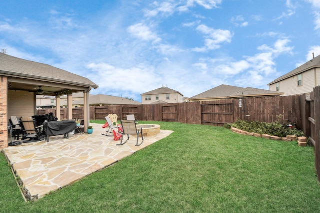 view of yard with a fire pit, ceiling fan, and a patio