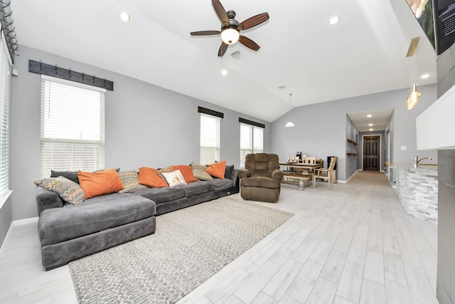 living room featuring lofted ceiling, light wood-type flooring, and ceiling fan