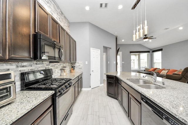 kitchen featuring black appliances, light stone countertops, pendant lighting, sink, and dark brown cabinets