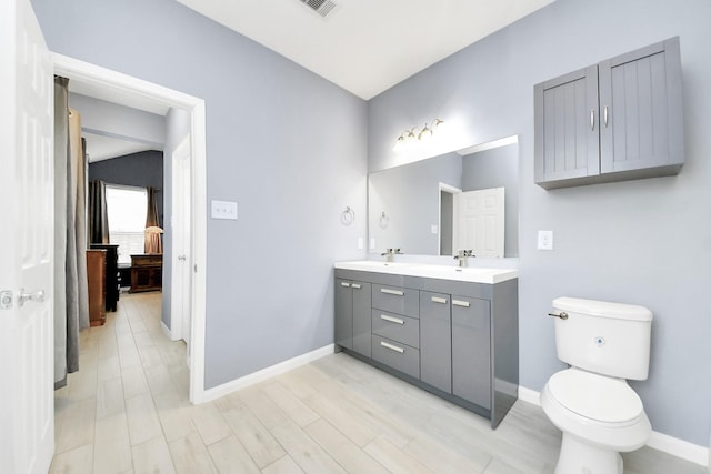 bathroom with lofted ceiling, vanity, and toilet