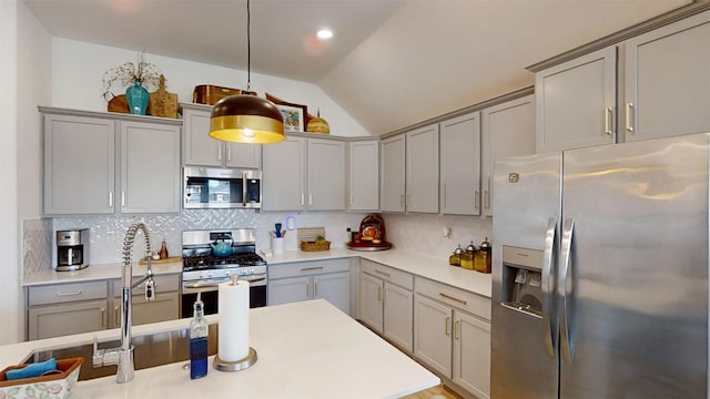 kitchen with vaulted ceiling, gray cabinets, stainless steel appliances, pendant lighting, and decorative backsplash