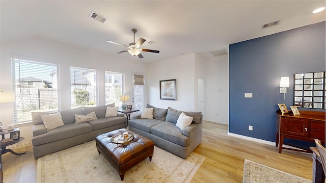 living room with a healthy amount of sunlight, ceiling fan, and light hardwood / wood-style flooring