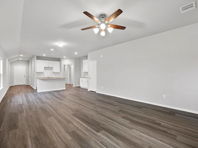 unfurnished living room featuring ceiling fan, dark wood-type flooring, and vaulted ceiling