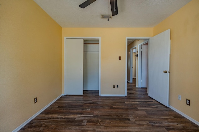 unfurnished bedroom with dark hardwood / wood-style flooring, a closet, ceiling fan, and a textured ceiling