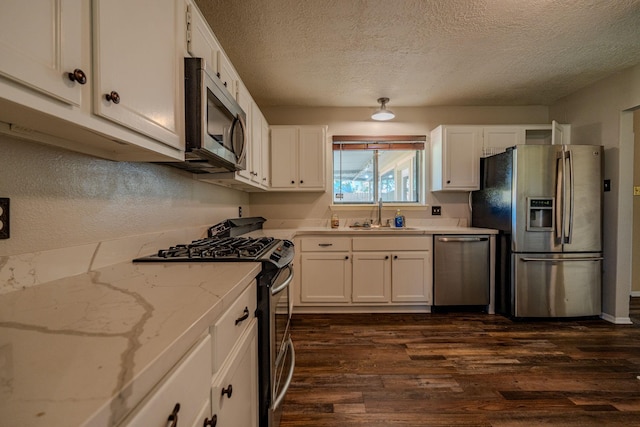 kitchen featuring a textured ceiling, stainless steel appliances, dark hardwood / wood-style flooring, white cabinetry, and sink