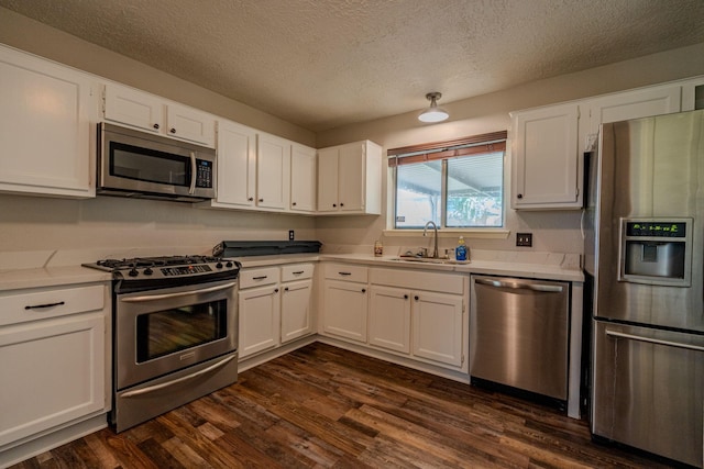 kitchen with a textured ceiling, dark hardwood / wood-style floors, stainless steel appliances, white cabinets, and sink