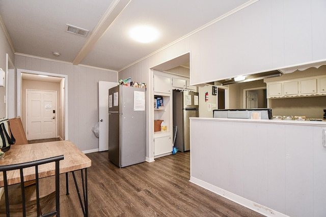 kitchen featuring crown molding, dark hardwood / wood-style floors, stainless steel refrigerator, and white cabinets