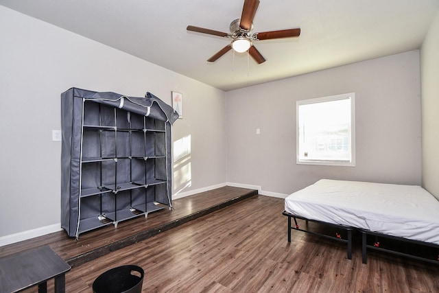 bedroom with multiple windows, dark hardwood / wood-style floors, and ceiling fan