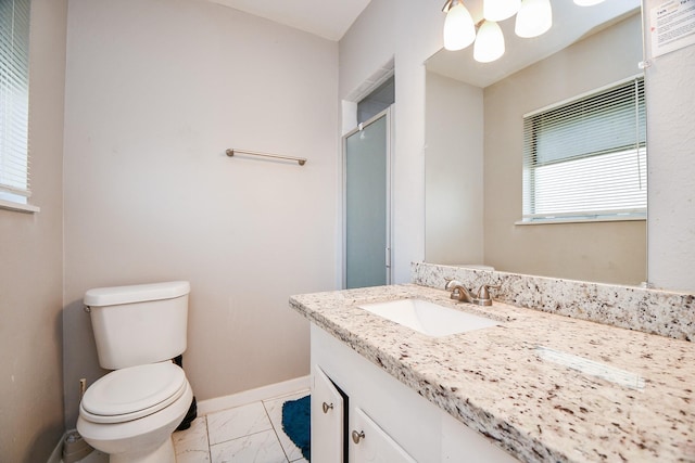 bathroom featuring vanity, a shower with shower door, and toilet