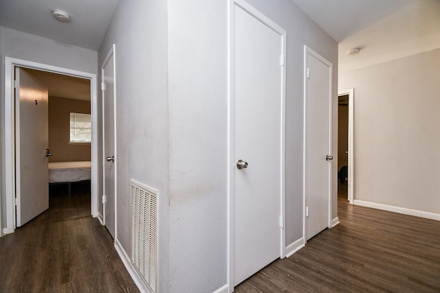 corridor with dark hardwood / wood-style flooring