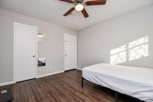 bedroom with dark hardwood / wood-style flooring and ceiling fan