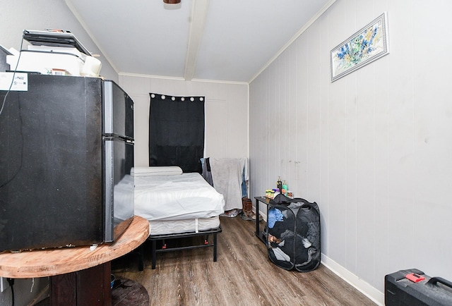 bedroom featuring fridge, wood-type flooring, and crown molding