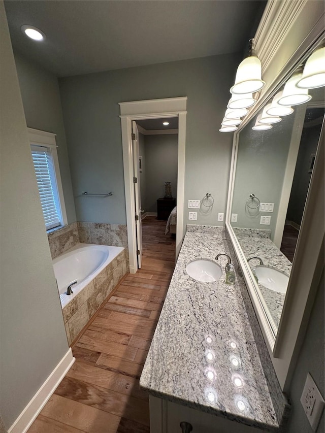 bathroom featuring vanity, hardwood / wood-style floors, and tiled tub