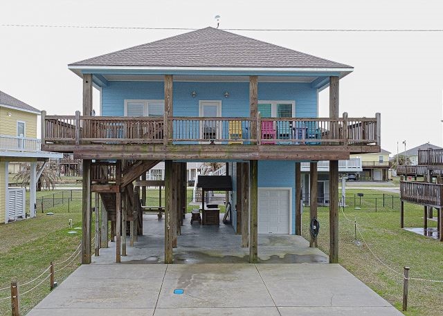 view of front facade featuring a carport, a garage, a porch, and a front lawn