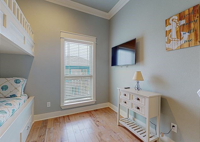 bedroom with ornamental molding and light hardwood / wood-style floors