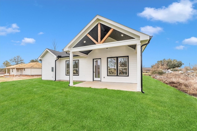 rear view of property featuring a patio area and a yard