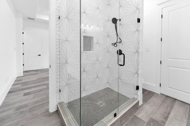 bathroom featuring a shower with door and hardwood / wood-style floors