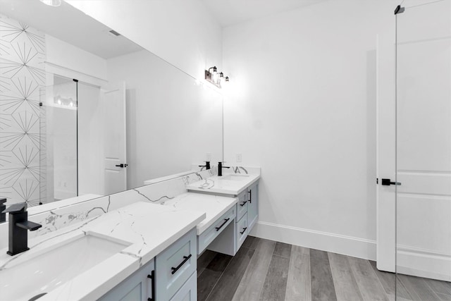 bathroom with hardwood / wood-style flooring, walk in shower, and vanity