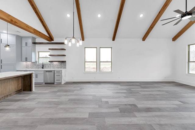 kitchen with decorative light fixtures, ceiling fan, stainless steel dishwasher, backsplash, and beam ceiling