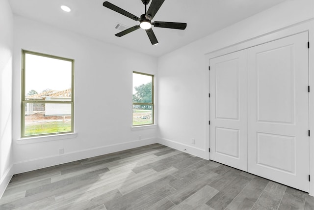 unfurnished bedroom with ceiling fan, light hardwood / wood-style floors, and a closet