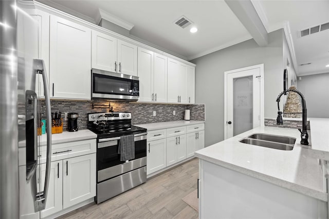 kitchen with stainless steel appliances, sink, white cabinets, ornamental molding, and tasteful backsplash