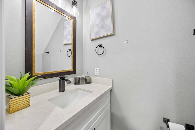 bathroom featuring vaulted ceiling and vanity