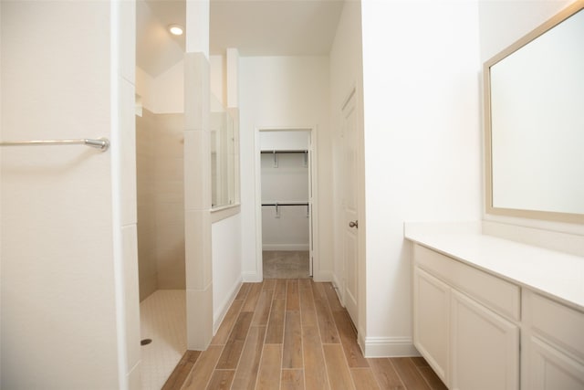 bathroom featuring a tile shower and vanity