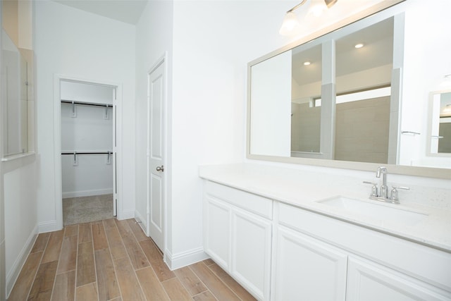 bathroom featuring walk in shower and vanity