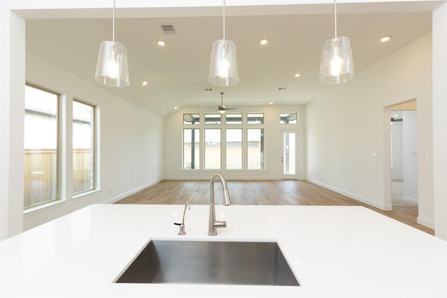 kitchen featuring sink, ceiling fan, vaulted ceiling, and hanging light fixtures