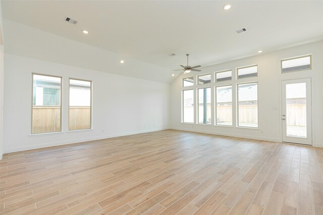 empty room with light hardwood / wood-style floors, vaulted ceiling, ceiling fan, and plenty of natural light