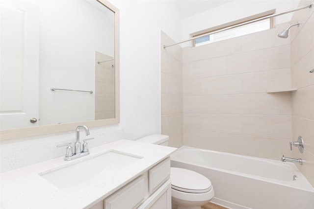 full bathroom with vanity, tiled shower / bath combo, and toilet