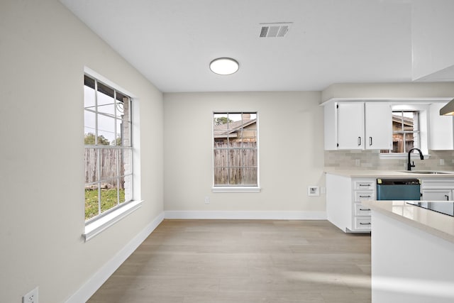 kitchen with sink, white cabinetry, tasteful backsplash, and dishwasher