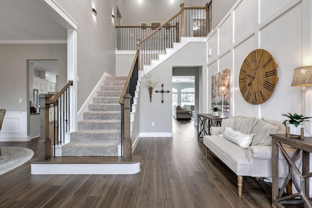 entrance foyer with crown molding and dark wood-type flooring