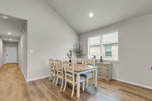 dining space featuring light hardwood / wood-style floors and lofted ceiling