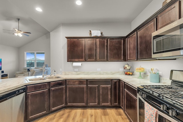 kitchen with sink, vaulted ceiling, light hardwood / wood-style floors, dark brown cabinets, and appliances with stainless steel finishes