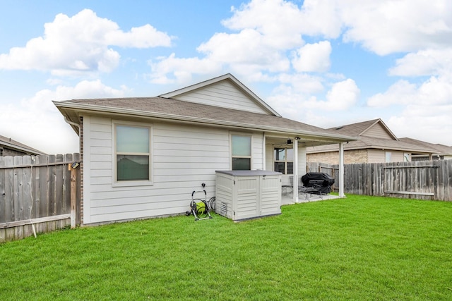 rear view of property with ceiling fan, a patio, and a yard