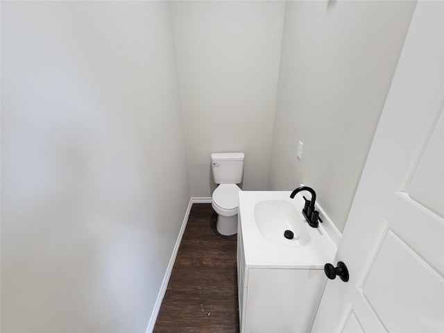 bathroom with toilet, wood-type flooring, and vanity