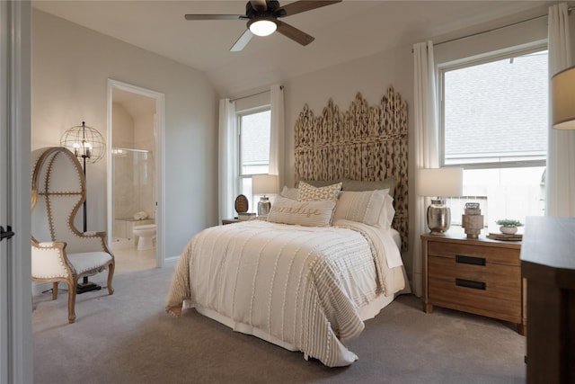 bedroom with ceiling fan with notable chandelier, multiple windows, light colored carpet, and connected bathroom