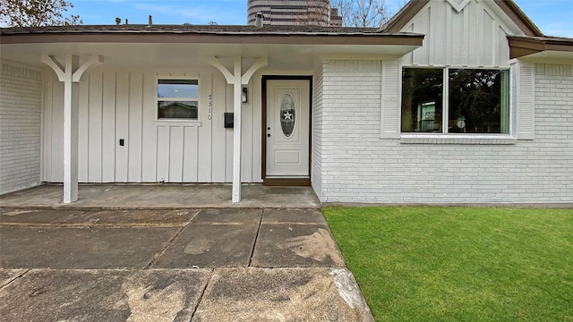 property entrance with a lawn