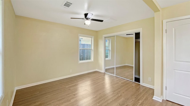 unfurnished bedroom featuring ceiling fan, a closet, and wood-type flooring