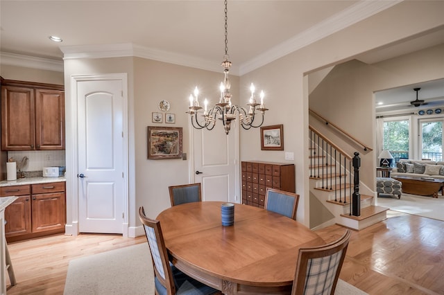 dining space with ceiling fan with notable chandelier, light wood-type flooring, and ornamental molding