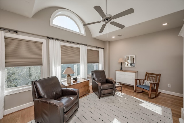 living area featuring light wood-type flooring, ceiling fan, vaulted ceiling, and plenty of natural light