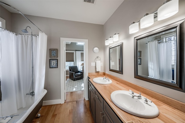 bathroom with vanity, hardwood / wood-style floors, and shower / bath combination with curtain