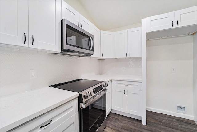 kitchen with lofted ceiling, white cabinets, dark hardwood / wood-style floors, and appliances with stainless steel finishes