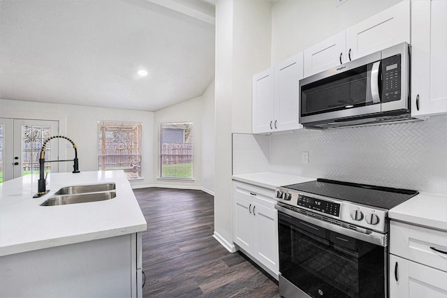 kitchen featuring appliances with stainless steel finishes, white cabinets, plenty of natural light, and sink