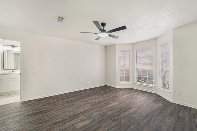 empty room with a textured ceiling and dark hardwood / wood-style floors